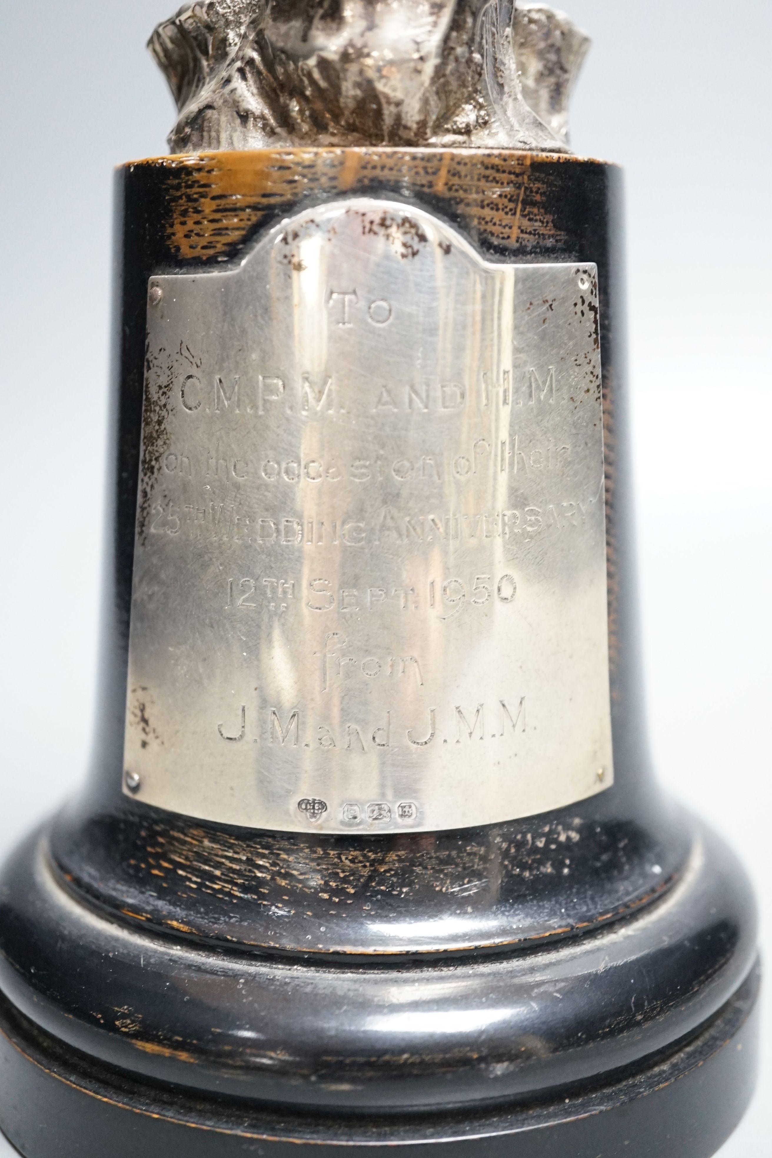 A late 1940's silver presentation figure of a young boy playing the pipes, on a rocky base, Goldsmiths & Silversmiths Co Ltd, London, 1949, on a wooden plinth with engraved presentation plaque, overall height 23.5cm